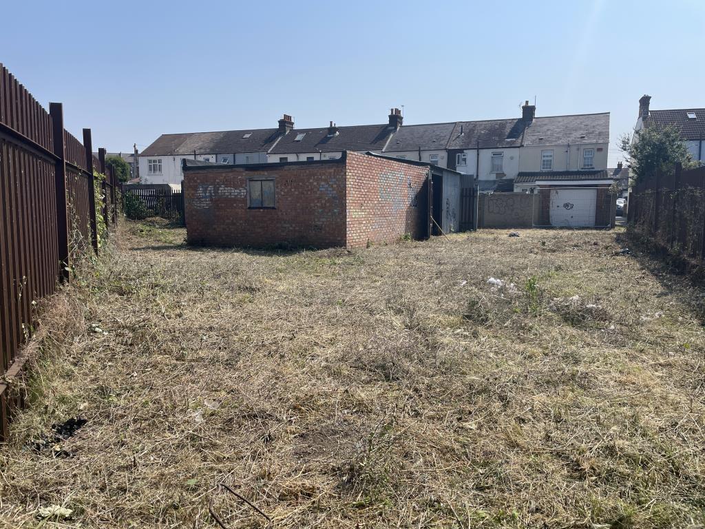 Lot: 66 - DEVELOPMENT OPPORTUNITY WITH OUTLINE PLANNING FOR TWO DETACHED BUNGALOWS - outside image of site from western corner looking back east